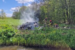 Auto in brand langs dijk in Wijdewormer