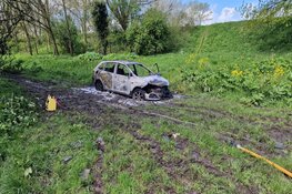 Auto in brand langs dijk in Wijdewormer